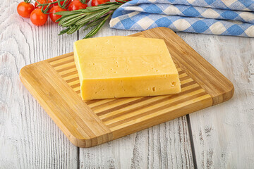 Piece of natural organic cheese over board