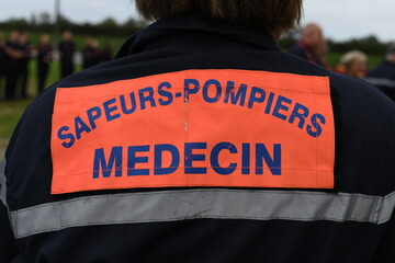 Picture of the back of a doctor specialized in emergency situations such as natural disasters. Equipped with a high visibility jacket for quick identification of each member of the intervention team.