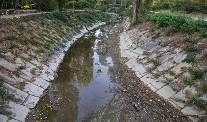 River bed almost completely without water in autumn. Climate change concept. Bologna, Italy.