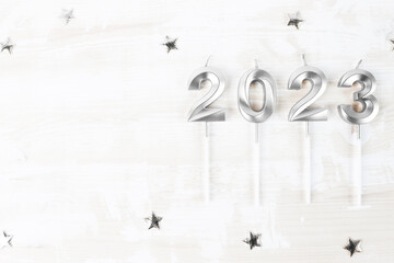 Festive background for christmas and new year. Numerals with the date 2023 in silver color on a white wooden board with copy space.