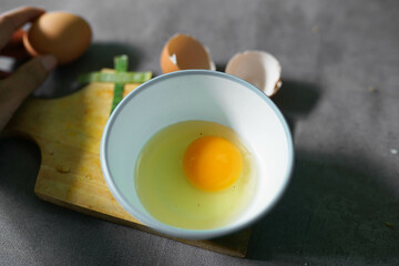fried chicken eggs ready to cook in a bowl with a concrete background