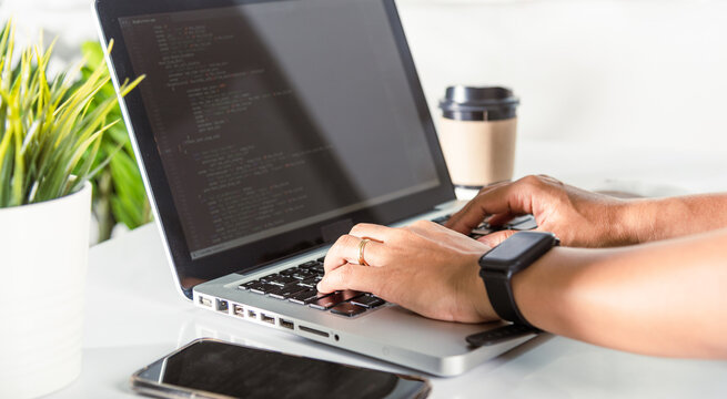 Programmer woman writing program HTML code sitting at workplace in office
