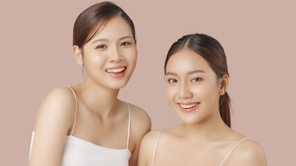 Close up portrait beauty shot of two young beautiful Asian girls looking at camera isolated on...