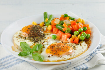 Fried eggs with vegetables. Traditional delicious breakfast and lunch.