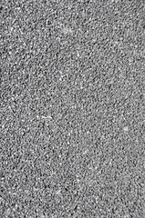 Gray fine asphalt texture. Background of dark gray small road stones. Fine rough surface