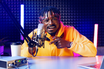 Happy young african man audio blogger broadcasting at studio
