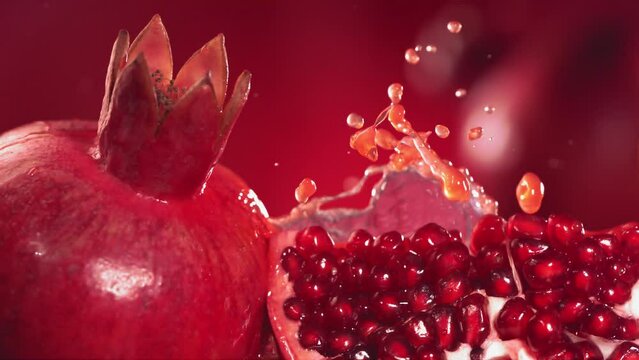 Slow Motion Shot of Pomegranate Juice Splashing through Pomegranate Slices