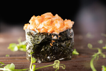 Gunkan Maki Sushi with Seafood, caviar and Spicy Sauce. Delicious Gunkan Sushi on table.