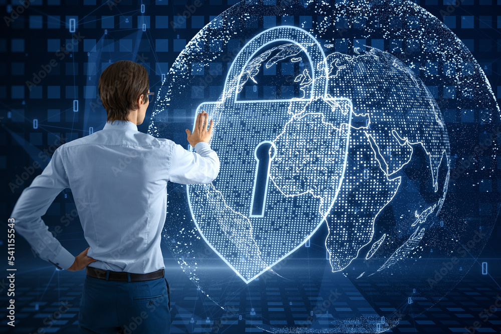 Poster Back view of business man using abstract glowing padlock and globe hologram on blurry blue background. Global web safety and protection concept.