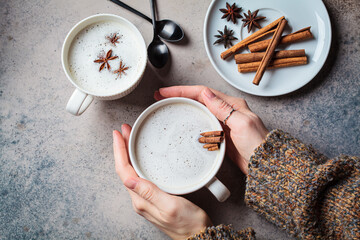 Homemade chai latte with cinnamon and star anise in white cup, dark background. - obrazy, fototapety, plakaty