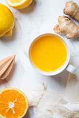 Ginger orange drink in white mug. Winter vitamin beverage for immunity boosting.