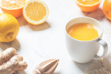 Ginger orange drink in white mug. Winter vitamin beverage for immunity boosting.