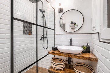 Simple bathroom with black shower, round mirror and classic white tiles © Pavel