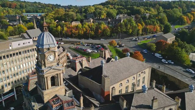 Aerial footage of the market town centre of Dewsbury in West Yorkshire in the UK showing the historical town centre, streets, roads and townhall.