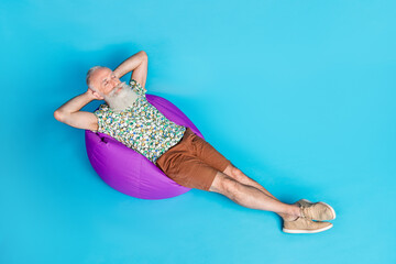 Full body high angle view portrait of peaceful sleeping aged man isolated on blue color background