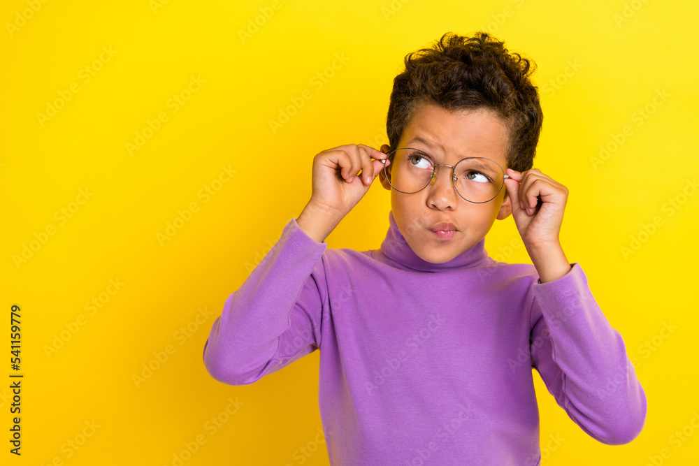 Wall mural portrait of minded pensive person arms touch eyewear look empty space isolated on yellow color backg