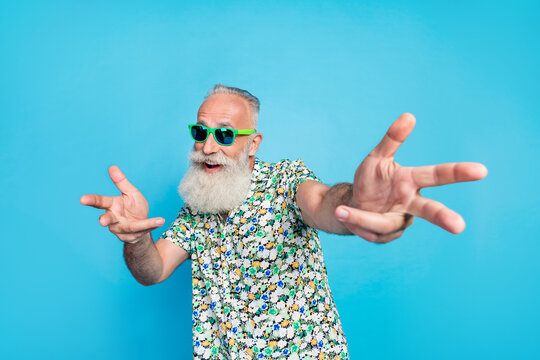 Photo of old age pensioner funny macho grandfather wear summer shirt green glasses good hairstyle hands directing you isolated on blue color background