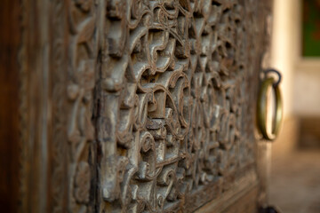 An ancient, massive, deeply carved elm door at a mausoleum in Khiva. Uzbekistan.