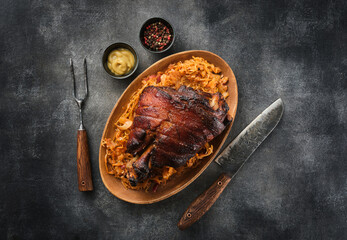 Schweinshaxe, in German cuisine, is a roasted ham hock (or pork knuckle). Roast pork knuckle with sauerkraut. - obrazy, fototapety, plakaty