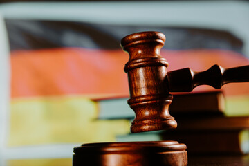 Judge wooden gavel and flag of Germany.