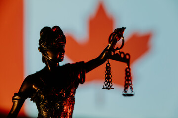 Lady Justice close-up against Canada flag. Law concept