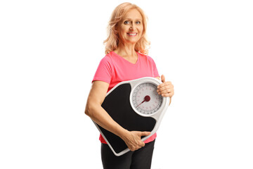 Smiling mature woman in sportswear holding a measuring scale