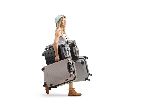 Full length profile shot of a young woman walking and carrying many suitcases