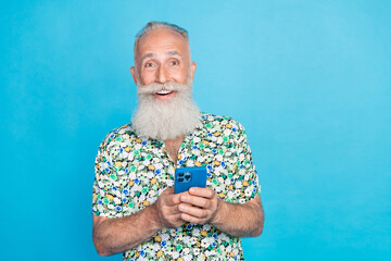Photo of funky satisfied aged man hold use telephone chatting isolated on blue color background