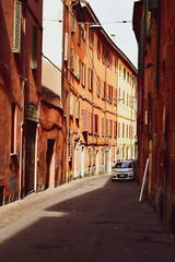 Fototapeta na wymiar Old narrow street in Bologna, Emilia Romagna, Italy. Architecture and landmark of Bologna. Cozy cityscape of Bologna.