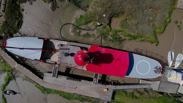 Aerial view above a lightship stuck in mud at low tide, sunny Tollesbury, UK - screwdriver, drone shot