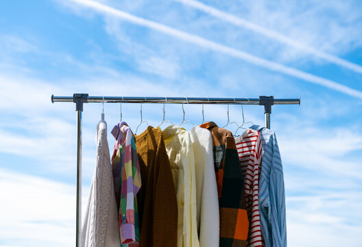  Low angle view at colourful clothes hanging on rail against blue sky.