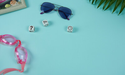 Sunglasses and goggles with dice on a blue background. The concept is weekend planning.