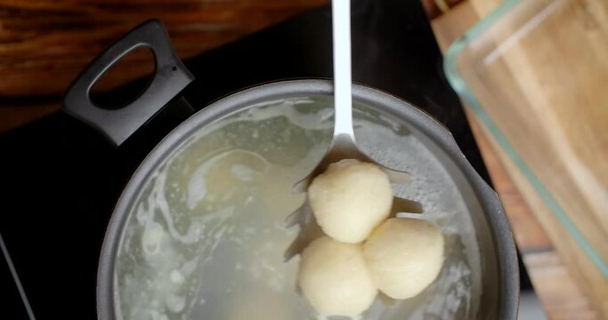 Chef cooks potato dumplings in a pot of boiling water