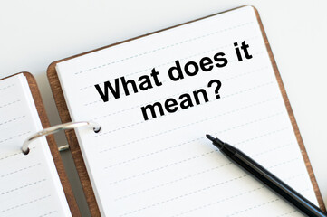 text what does it mean written on notepad with penciland white background. High quality photo