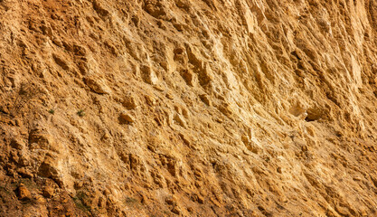 Abstract natural background. Yellow surface sandy quarry slope. Mining of natural materials and construction concept