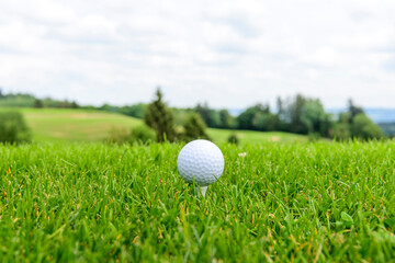 Golfball abschlagsbereit auf einem Tee 