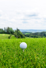 Golfball abschlagsbereit auf einem Tee 