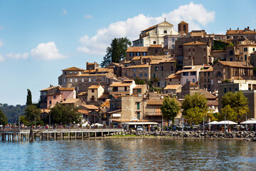 Fototapeta na wymiar From the shores of Lake Bracciano rises the picturesque medieval village of Anguillara Sabazia with its beautiful architecture