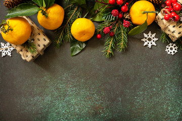 Cozy winter mood. Winter composition with fir branches,  xmas presents and tangerines on a stone...