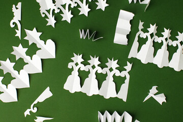 Christmas papercraft garland to decorate room at home for New Year 2-22, Merry Christmas. Step by step instructions. DIY winter craft project. Top view, traditional green background. Simple handcraft