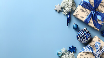 Merry Christmas and Happy New Year banner design. Blue Christmas background with gift boxes, blue and silver decorations, fir branches on pastel blue table