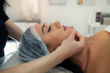 close up of beautician hands doing relaxing rejuvenating massage female client at spa salon