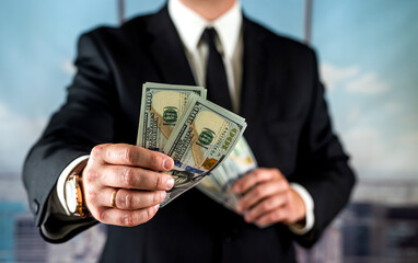 businessman man counts his profit for the month in his hands.