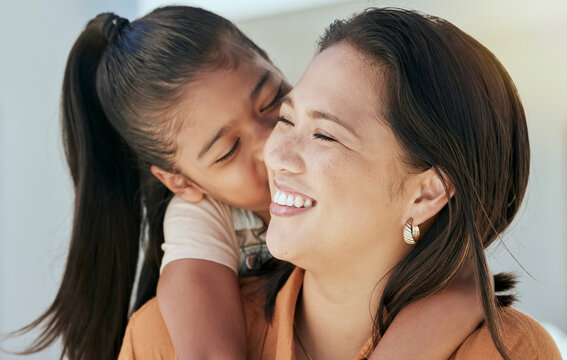 Happy Family, Mother And Girl Kiss, Hug And Relax In A Living Room, Together And Cheerful In Their Home. Love, Family And Kids With Smile, Embracing And Laughing Woman Enjoy Hugging Daughter At Home