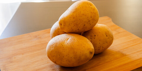 bunch of potatoes close up on wooden board
