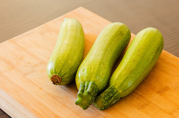 bunch of zucchini close up on wooden board