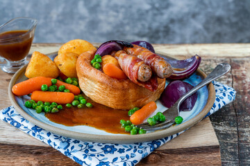 Toad in the hole with Yorkshire pudding, sausages and vegetables
