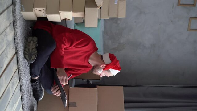 man entrepreneur small business owner is writes adress delivery at home office. Prepares boxes for shipment. Big sale for Christmas. home office is seller of online store. start-up.