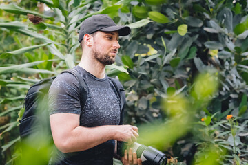 Photographer with hat and camera in forest