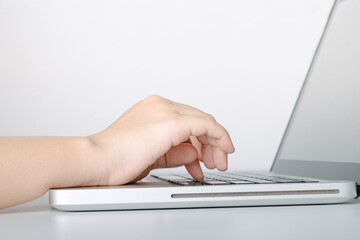 Closeup to female hand using computer laptop. Fingers typing the keyboard.
